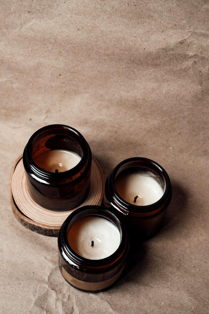 Assortment of elegant handmade candles in various sizes and types on wooden table